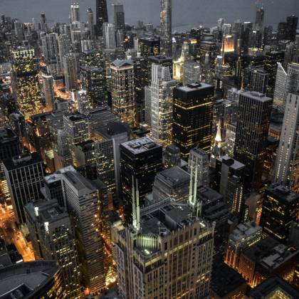 Explore The Vibrant Skyline Of Chicago With Its Illuminated Skyscrapers And Bustling Urban Life Captured At Dusk.