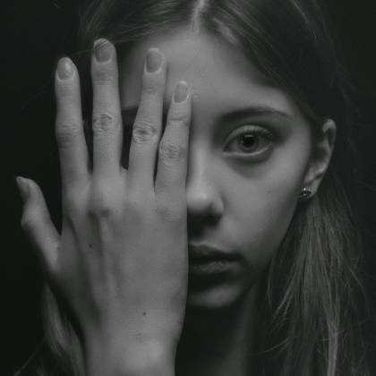 A Striking Black And White Portrait Of A Young Woman With A Contemplative Expression, Shot In A Studio.
