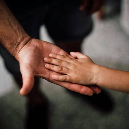 Close Up Of A Child's Hand Resting Gently On A Man's Hand, Symbolizing Love And Support.