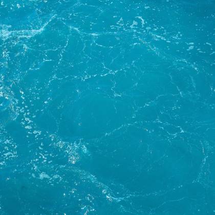 A Detailed And Vibrant View Of Turquoise Ocean Water With Light Reflections.