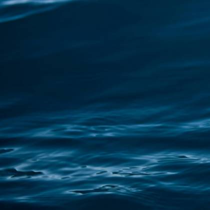 A Tranquil View Of Dark Blue Ocean Waves With Gentle Ripples And Motion.