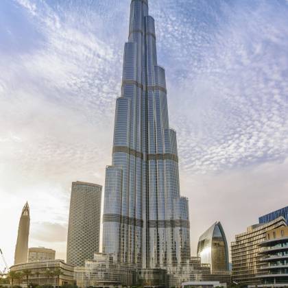 Majestic Burj Khalifa Against A Bright Blue Sky Reflecting In Water, Dubai.
