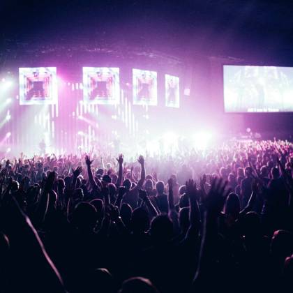 A Vibrant Concert Crowd Enjoying Live Music Under Stunning Stage Lights.