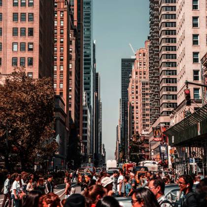 Vibrant Daylight Scene Capturing A Crowded Street In New York City Amidst Towering Skyscrapers.