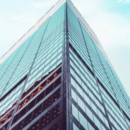Low Angle View Of A Modern Skyscraper In New York City Showcasing Architectural Design Against A Clear Sky.