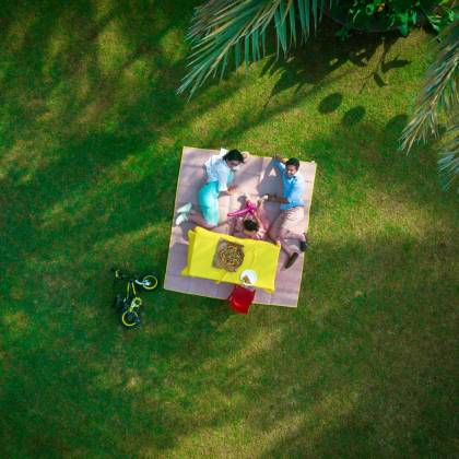 Aerial View Of A Family Enjoying A Picnic On A Bright Day In A Dubai Park.