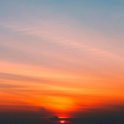 Dramatic Sunrise With Vibrant Orange And Blue Hues Painting The Sky, Creating A Serene And Peaceful Scene.