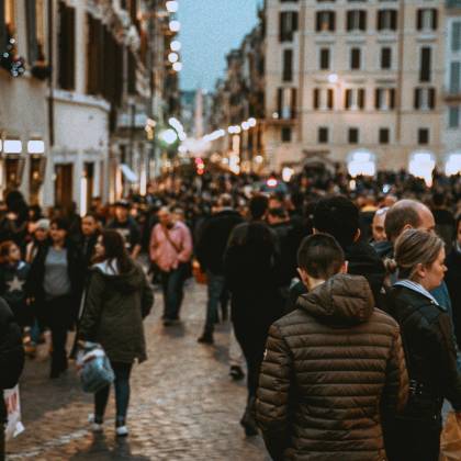 A Vibrant Street Filled With People In The Evening, Showcasing Urban Life And City Architecture.
