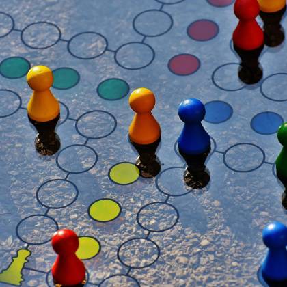 Close Up Of A Colorful Board Game With Pawns And A Dice, Perfect For Family Fun.