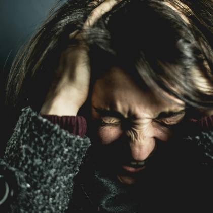 Close Up Of A Woman In Distress With Eyes Closed And Hands In Hair, Expressing Anxiety.