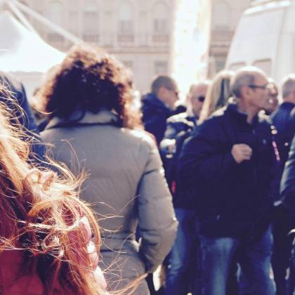 A Lively Group Of People Gathers In An Outdoor Setting During Daytime.