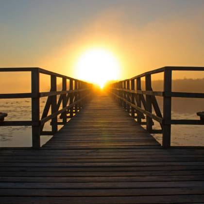 A Breathtaking Sunrise Over A Wooden Pier, Perfect For Relaxation And Reflection By The Water.