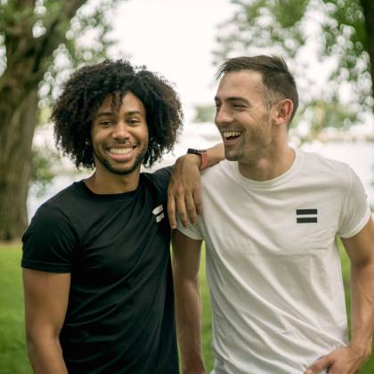 Two Friends Laughing And Enjoying A Sunny Day At A Park In Chicago.