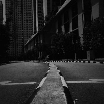 Dramatic Black And White Photo Of An Empty Urban Street With Tall Buildings.