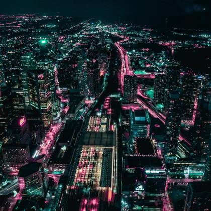 A Stunning Aerial View Of Toronto's Illuminated Cityscape At Night, Showcasing Vibrant Lights And Skyscrapers.