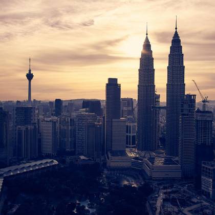 Explore Kuala Lumpur's Skyline Featuring The Iconic Petronas Towers At Sunset. Perfect For Travel And Architecture Enthusiasts.