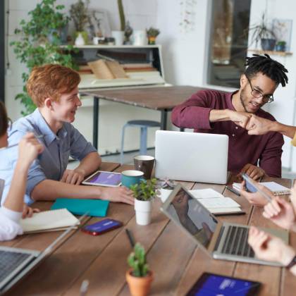A Diverse Group Of Young Professionals Brainstorming Around A Table In A Modern Office Environment.