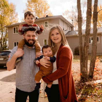 Smiling Family Of Four Enjoying A Sunny Autumn Day In Their Backyard.