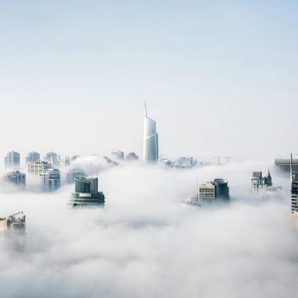 A Stunning View Of Dubai Skyscrapers Emerging Through A Blanket Of Fog, Showcasing Modern Architecture.