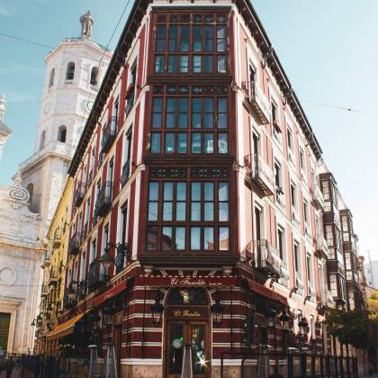 A Historic Building With A Cafe On A Sunny Street Corner In Spain, Showcasing Traditional Architecture.