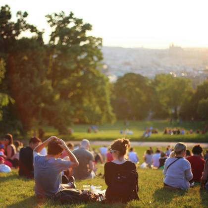 People Relaxing And Enjoying A Sunny Day In A Bustling City Park.