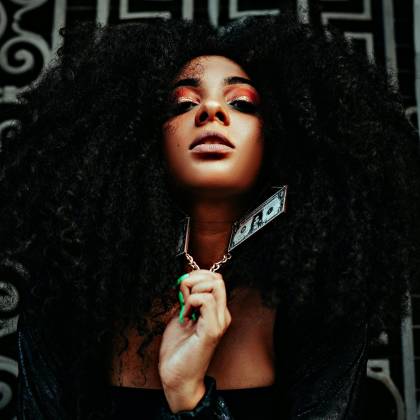 Dynamic Editorial Photo Of A Model With Afro Hair And Bold Makeup In An Urban Setting, Exuding Glamour And Edge.