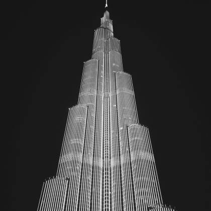 Black And White Photo Of Burj Khalifa At Night, Showcasing Its Striking Architecture Against The Sky.