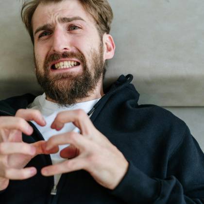 A Bearded Man Exhibiting Emotional Distress While Indoors, Capturing A Moment Of Intense Feeling.