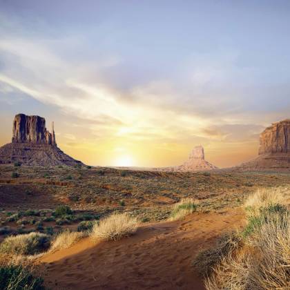 Breathtaking View Of Monument Valley's Iconic Rock Formations At Sunset, Showcasing Vivid Desert Landscape.