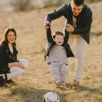 Family Enjoying Playful Soccer Game Outdoors, Capturing Joyful Moments.