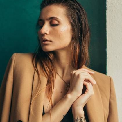 Stylish Portrait Of A Woman With A Brown Blazer And Nose Piercing, Capturing Elegance And Modern Fashion.