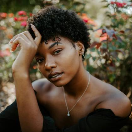 Close Up Portrait Of A Woman Surrounded By Vibrant Foliage, Showcasing Natural Beauty.
