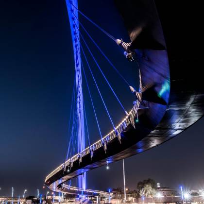 A Low Angle Shot Of An Illuminated Suspension Bridge Against A Clear Night Sky.