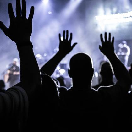 Silhouettes Of An Energetic Audience Cheering During A Live Concert In Houston.